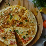 Crispy chicken quesadilla cut into wedges with guacamole and sour cream on the side